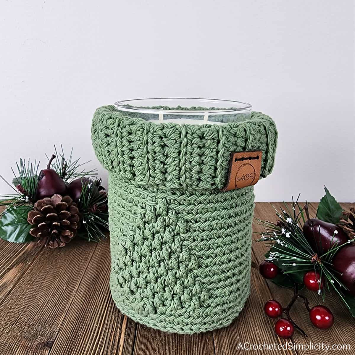 Green Christmas tree mason jar cozy holding a candle.