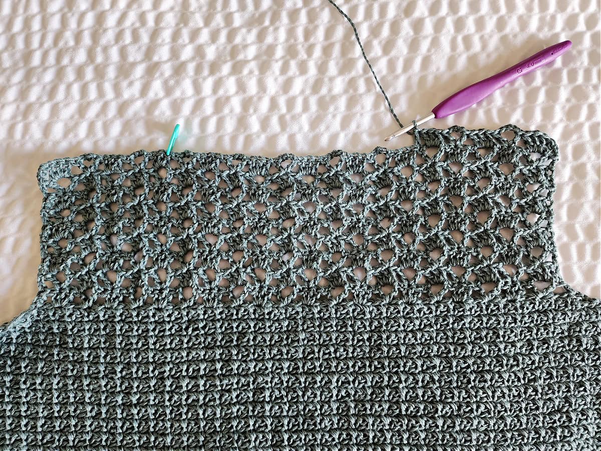A close-up of the shoulder being added to the front panel of the lacy crochet top.