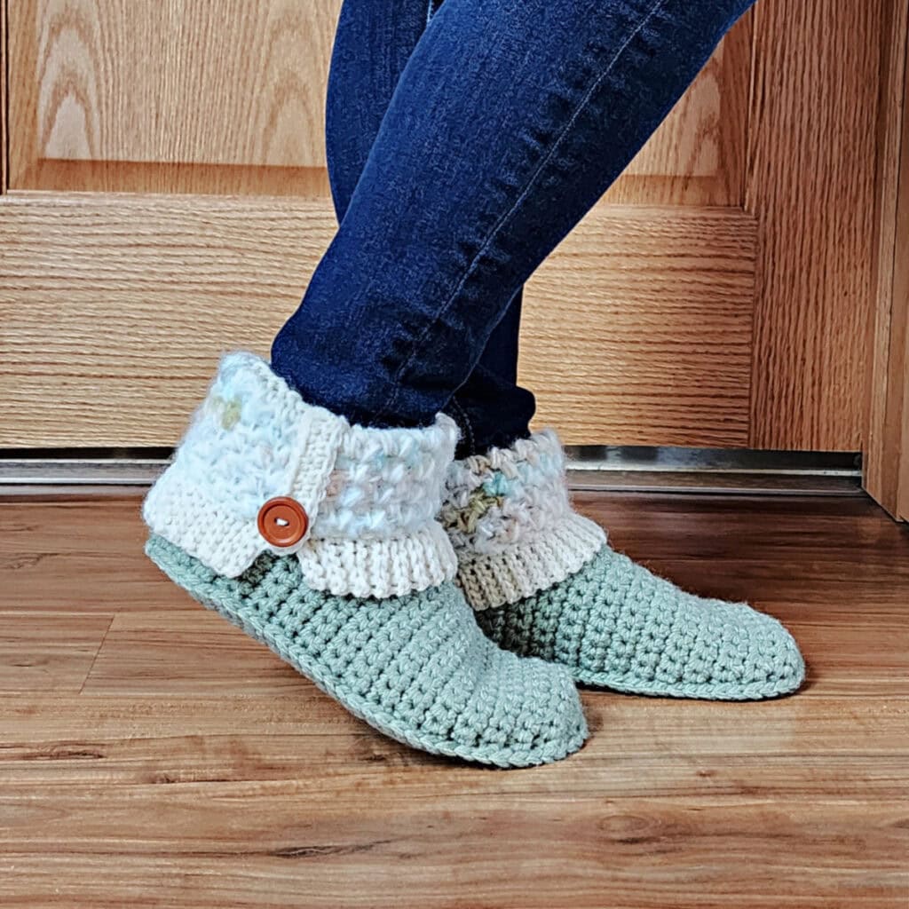 Model wearing jean jeggings and crochet slipper boots with cuff and brown buttons.