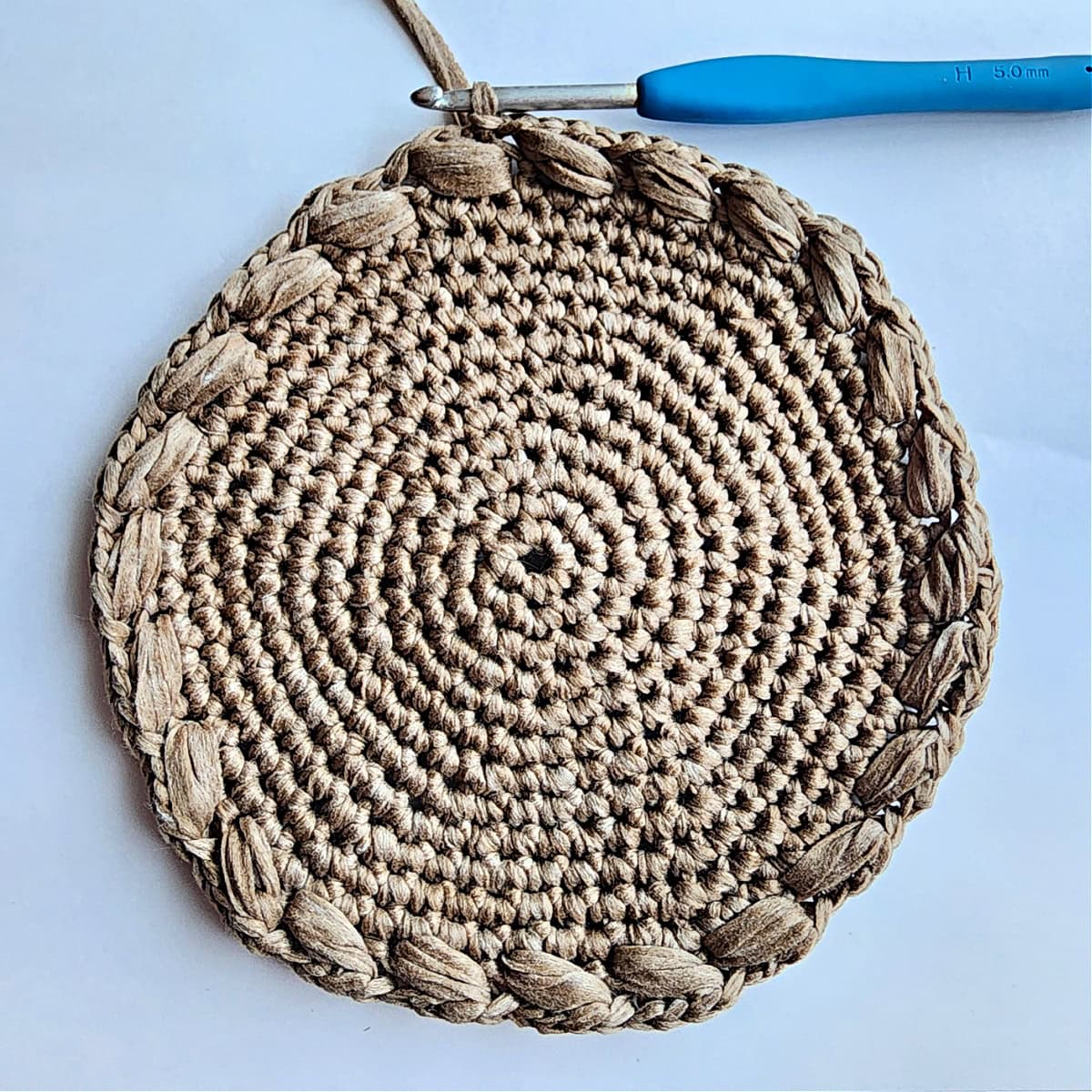 A round of diagonal puff stitches worked around a crochet circle.