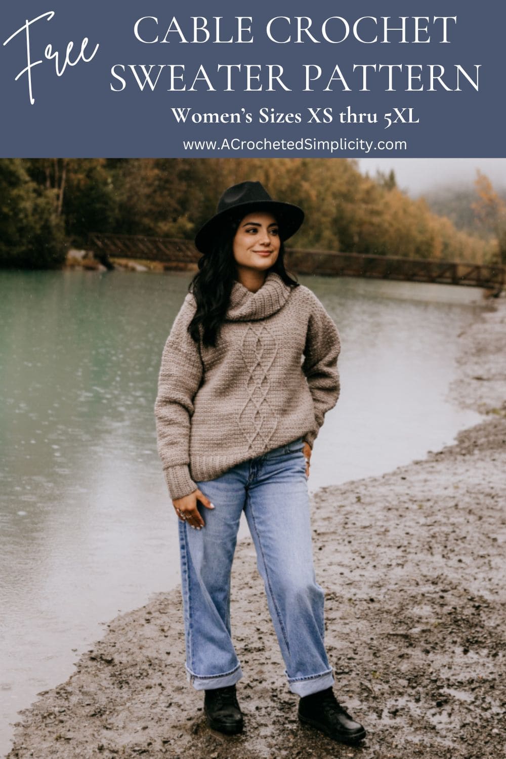 Young woman modeling a cable crochet sweater with a cowl neck near a river in Alaska.