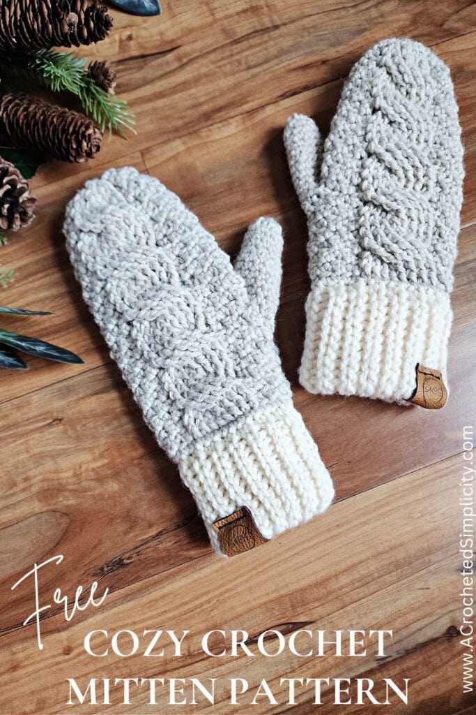 Two light beige cable crochet mittens with cream colored cuffs.