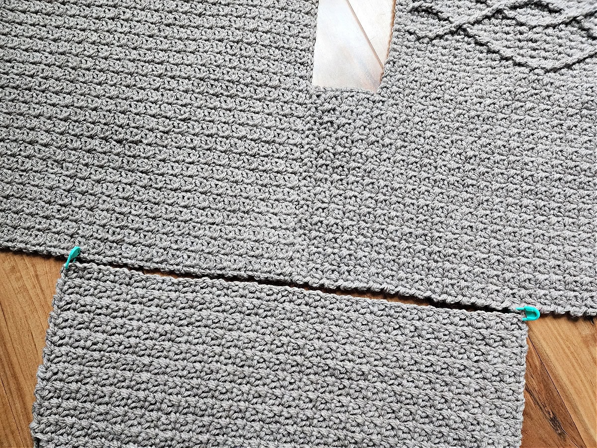 Close up of how to seam a sleeve to the cable crochet sweater.