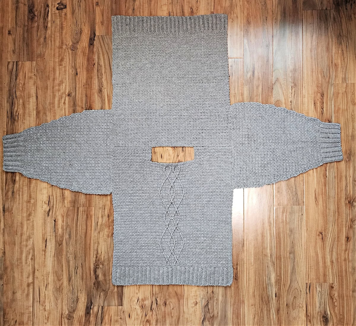 Four cable crochet sweater panels seamed at shoulders and sleeves.