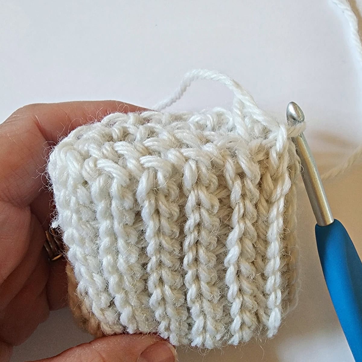 White crochet cuff folded inward to create a double layer cuff.