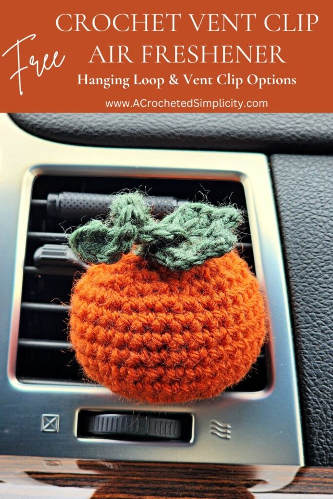 Crochet pumpkin car vent clip air freshener clipped into the vent in a car.