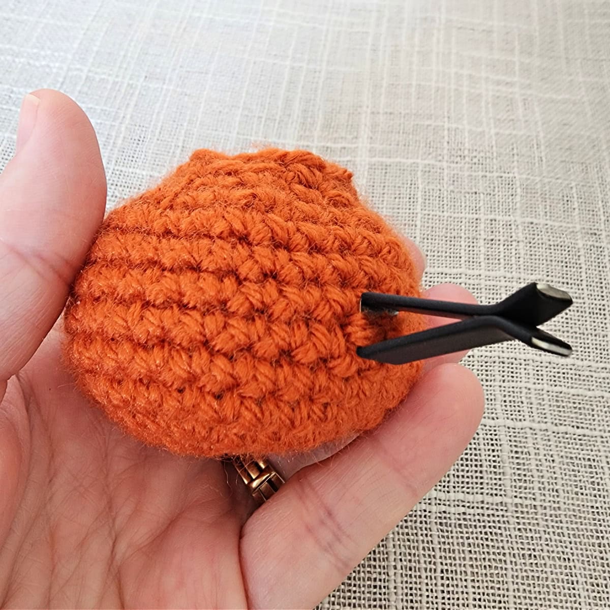 Metal vent clip attached to a mini crochet pumpkin.