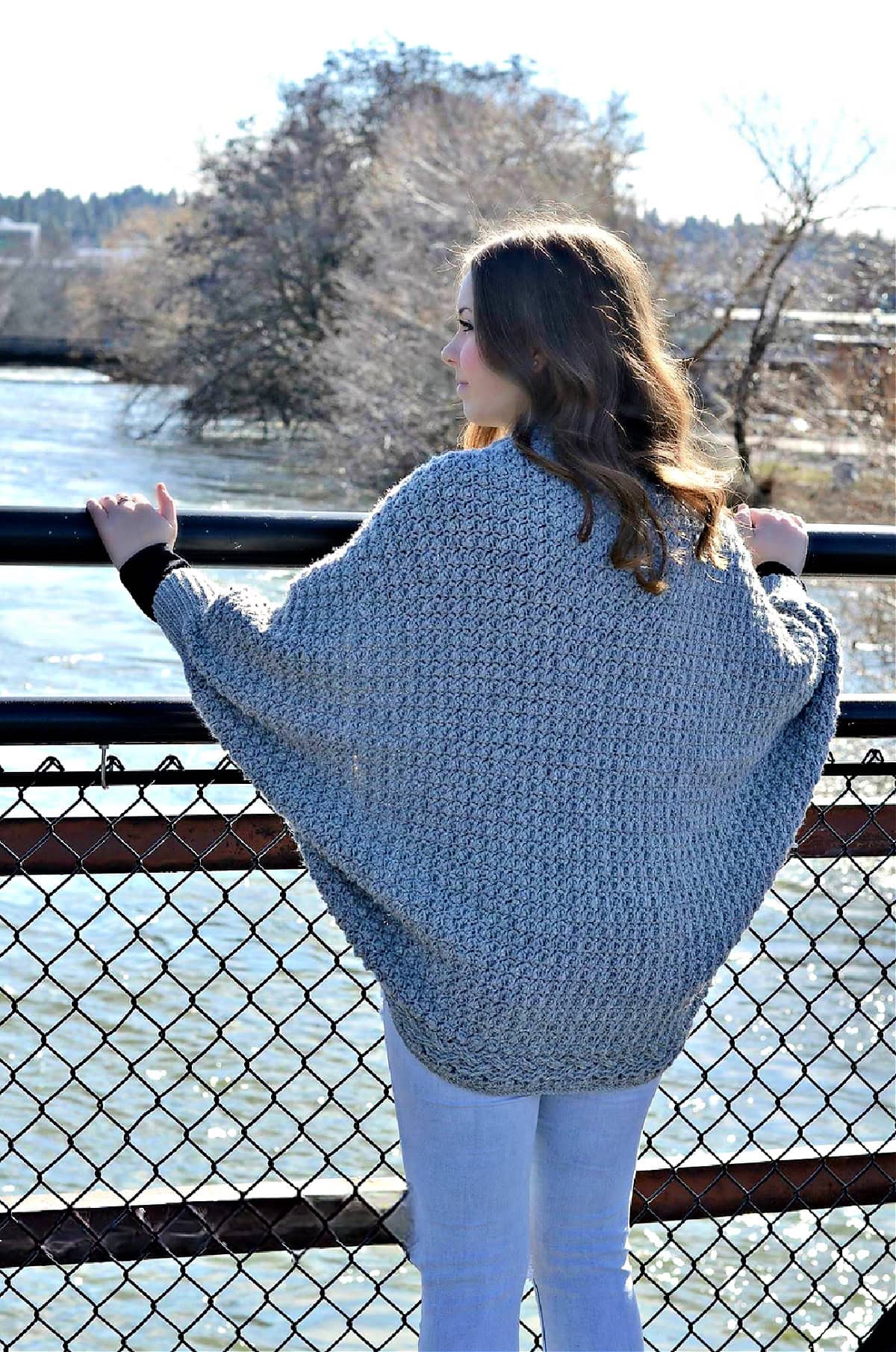 A woman with her back turned to show the back of a cocoon sweater.