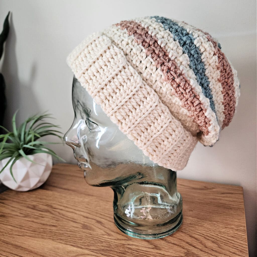 Tri color slouchy beanie crochet pattern on a glass mannequin head.