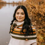 Young woman wearing a crochet cowl pattern as a capelet.