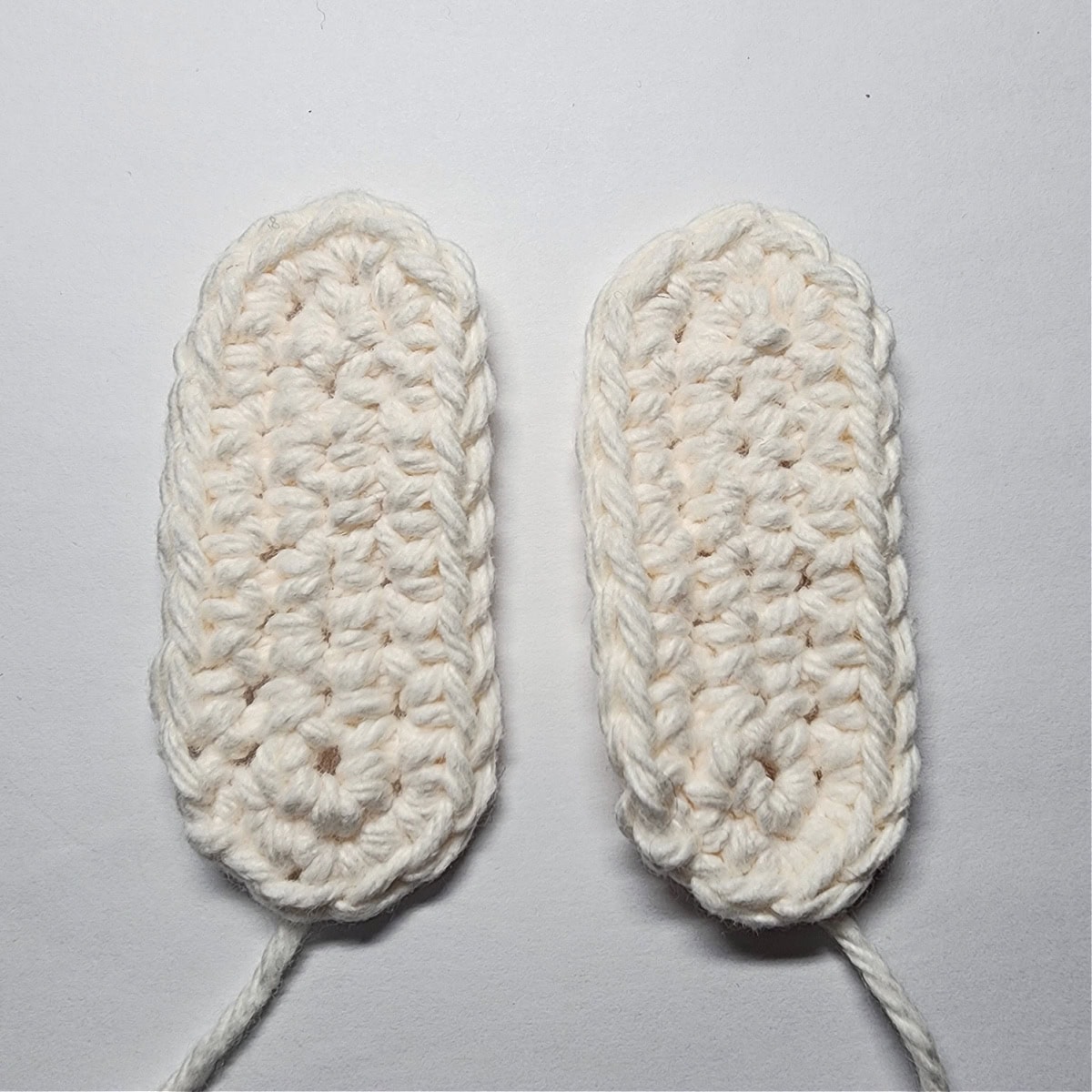 Two cream colored long ovals that become the elves hands.