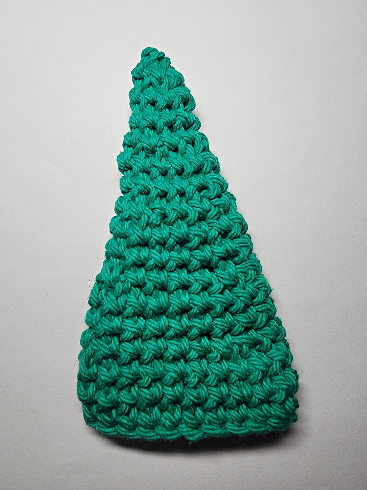 A green crocheted cone that becomes the elf hat.