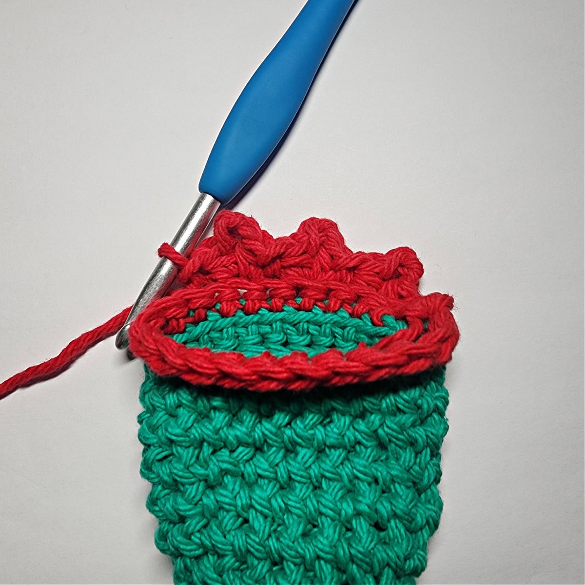 How to add the decorative trim on the elf hat with red yarn.