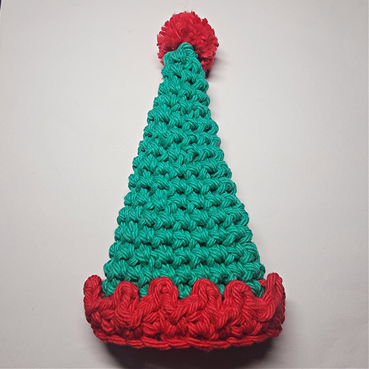 A green and red crocheted elf hat complete.