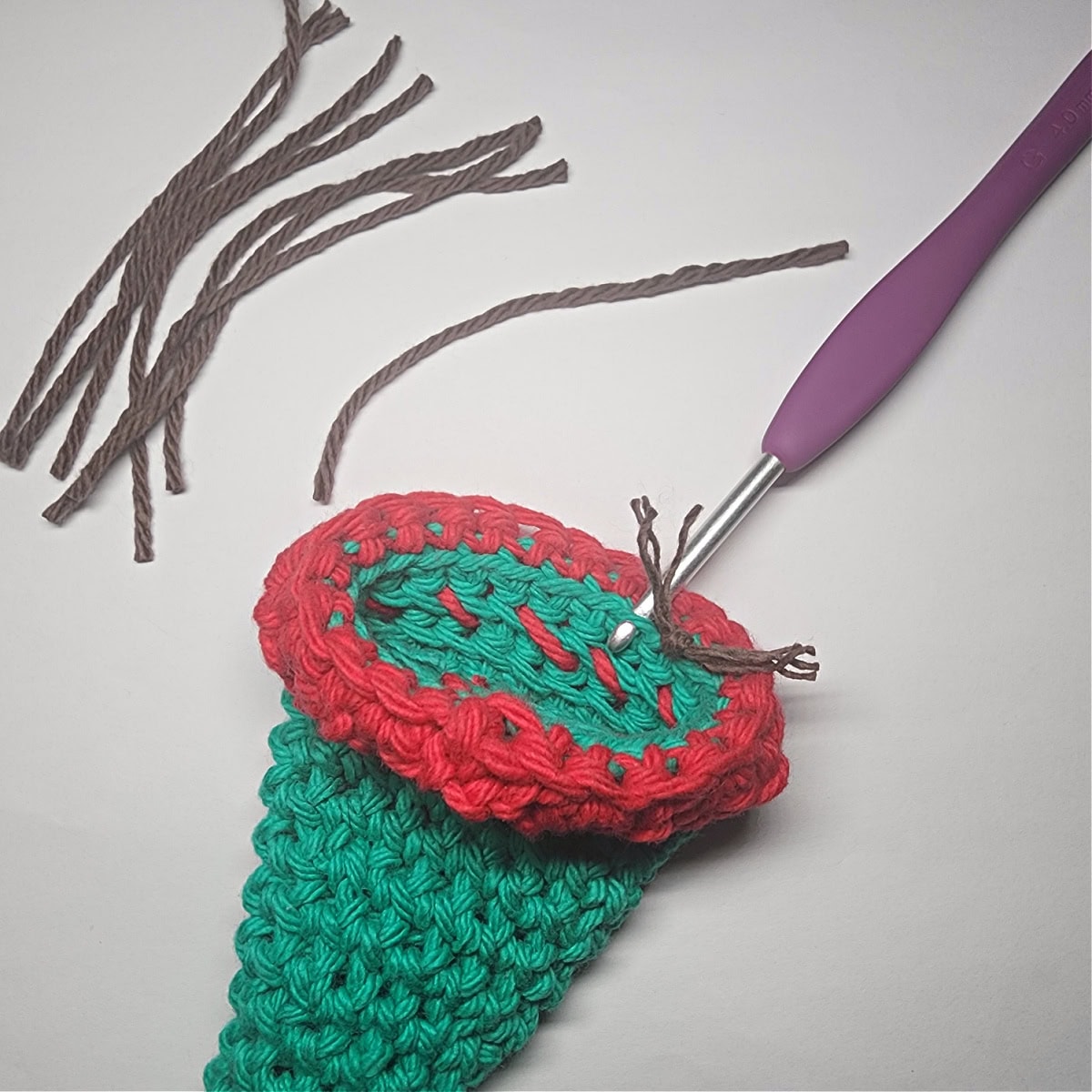 How to add brown yarn onto the elf hat for the elf's hair.