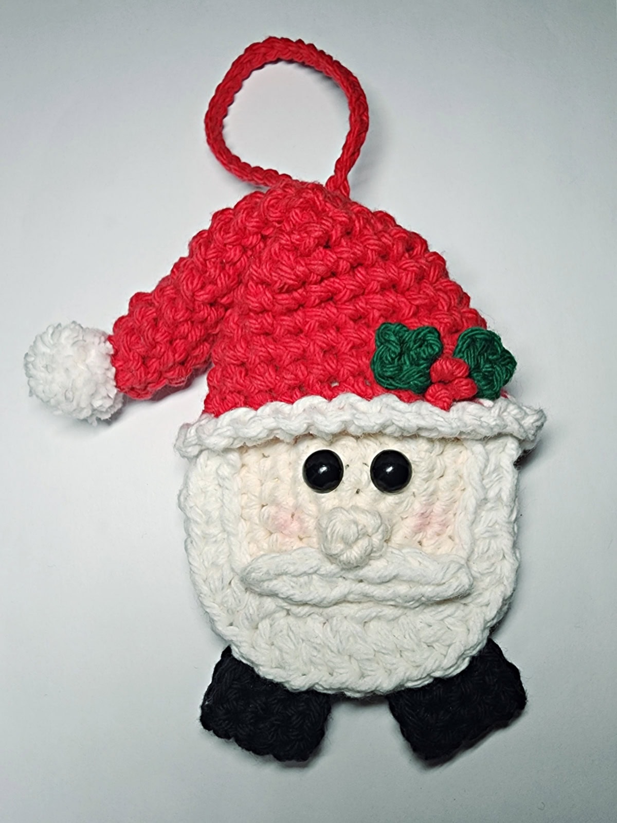 A crochet hanging loop attached to the top of the Santa ornament.