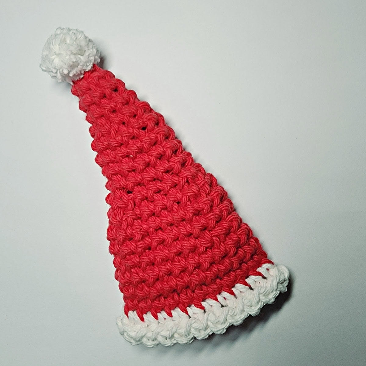 A Santa hat crochet pattern laying on a white background.