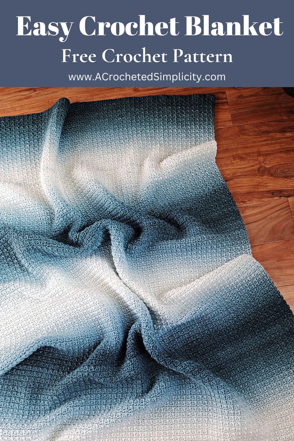 An easy crochet blanket pattern using a gradient yarn laid on a wooden floor.