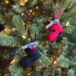 Black and red Santa boot crochet ornaments with holly leaves and berries.