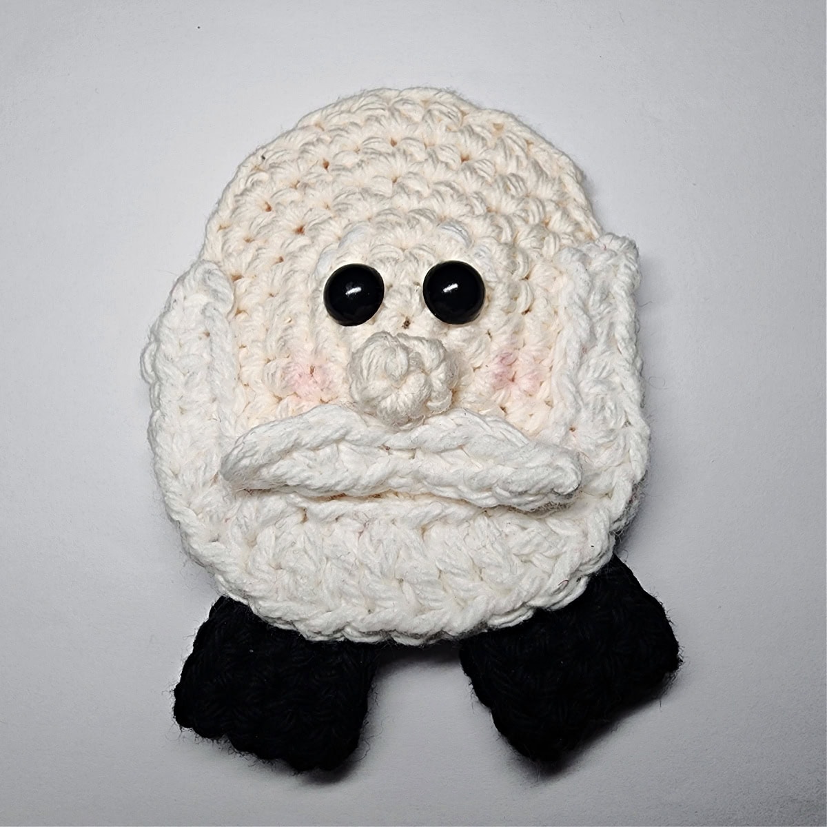 Crochet Santa ornament with a beard and mustache.