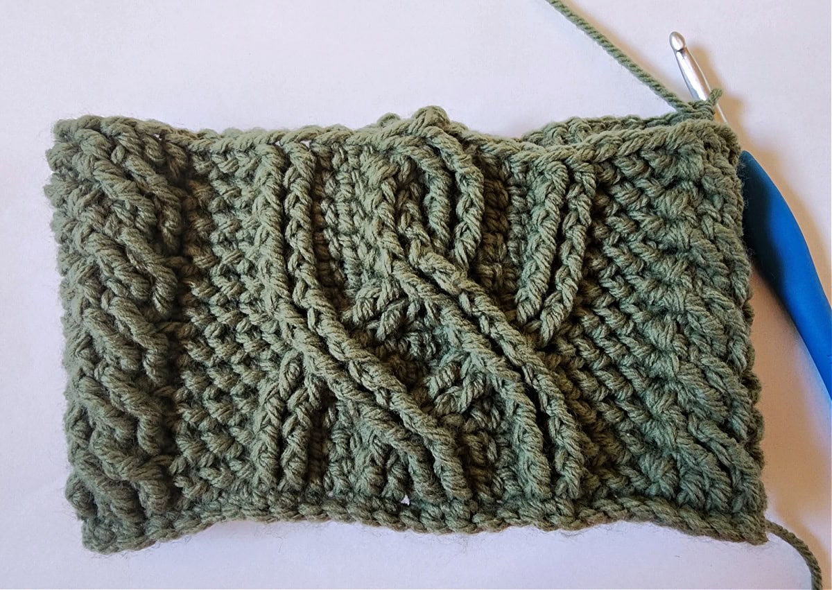 Green crochet Christmas stocking with a celtic crochet cable stitch pattern round 12.