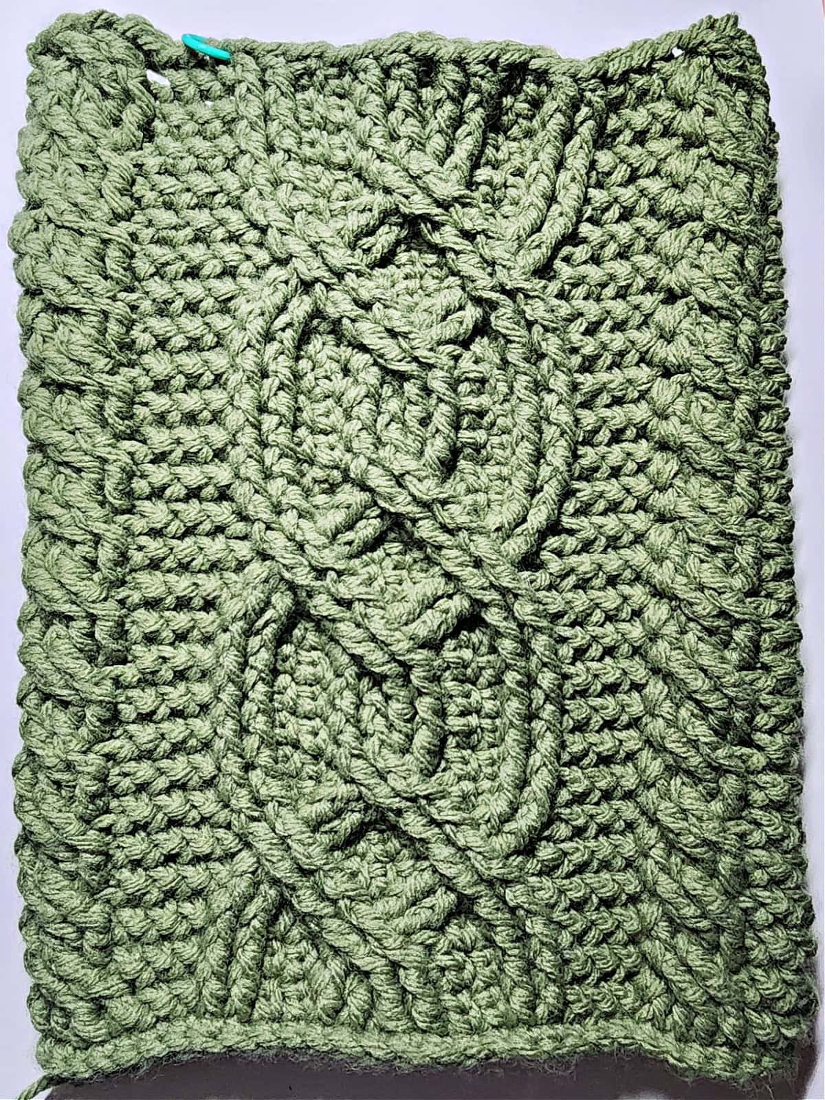 Green crochet Christmas stocking with a celtic crochet cable stitch pattern complete on the leg of the stocking.