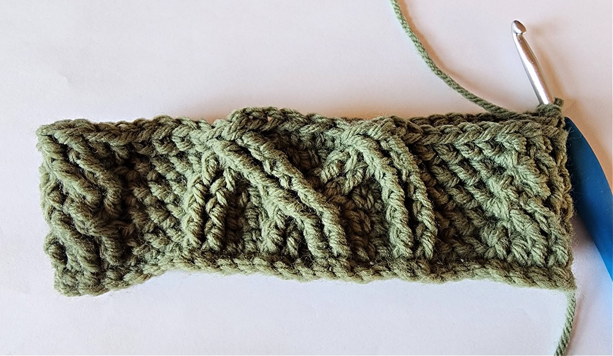 Green crochet Christmas stocking with a celtic crochet cable stitch pattern round 6.