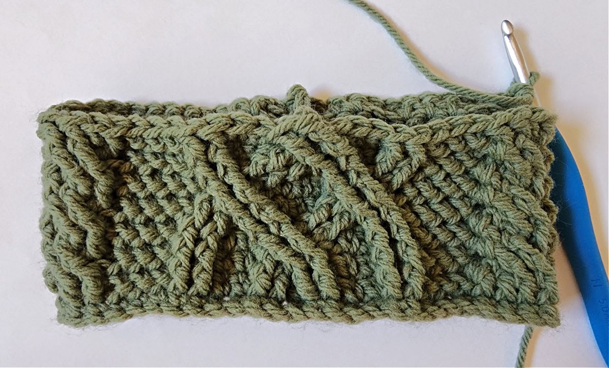 Green crochet Christmas stocking with a celtic crochet cable stitch pattern round 8.