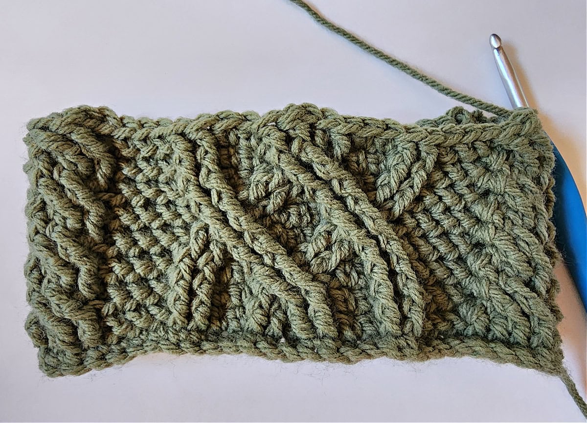 Green crochet Christmas stocking with a celtic crochet cable stitch pattern round 9.