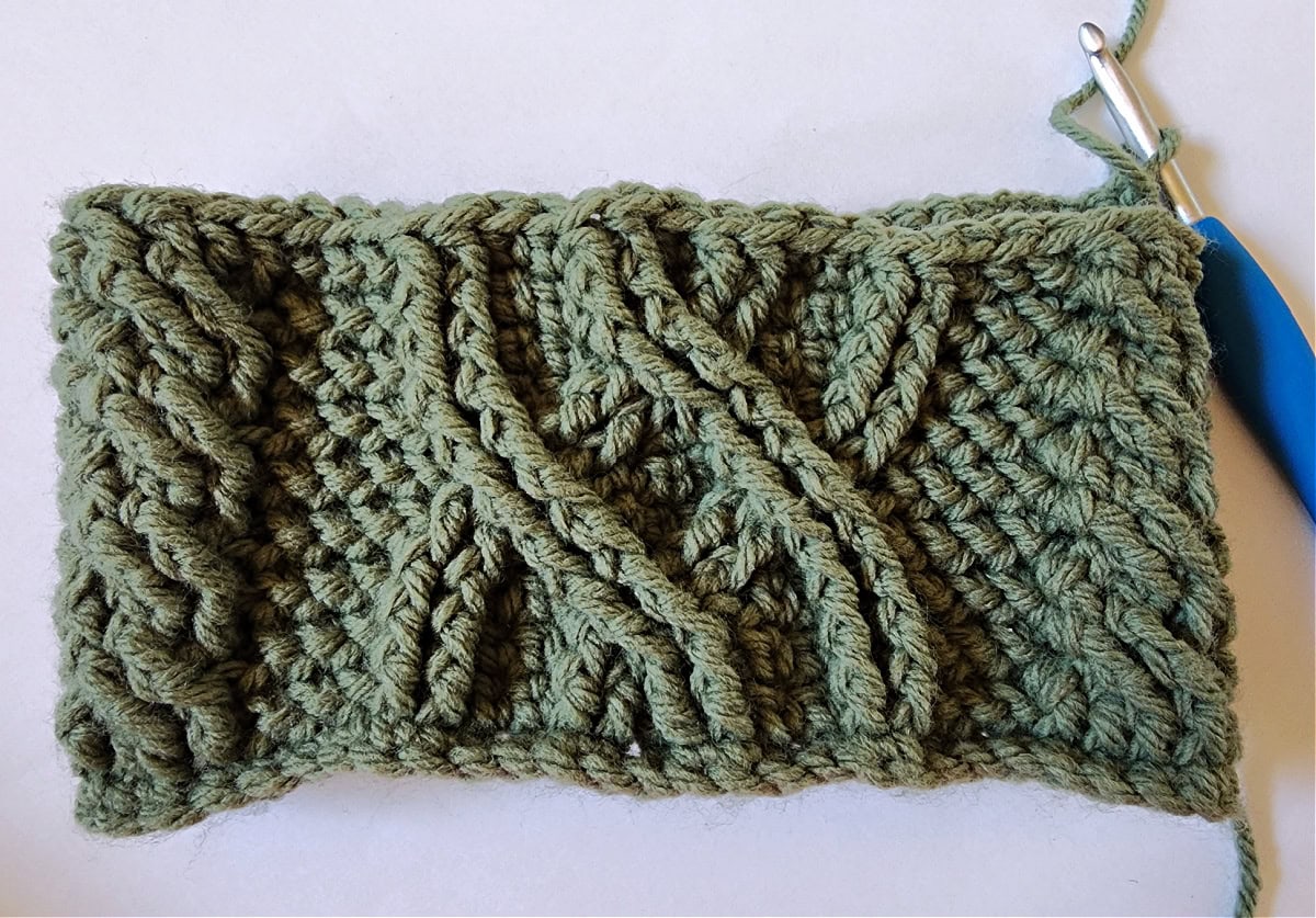 Green crochet Christmas stocking with a celtic crochet cable stitch pattern round 10.