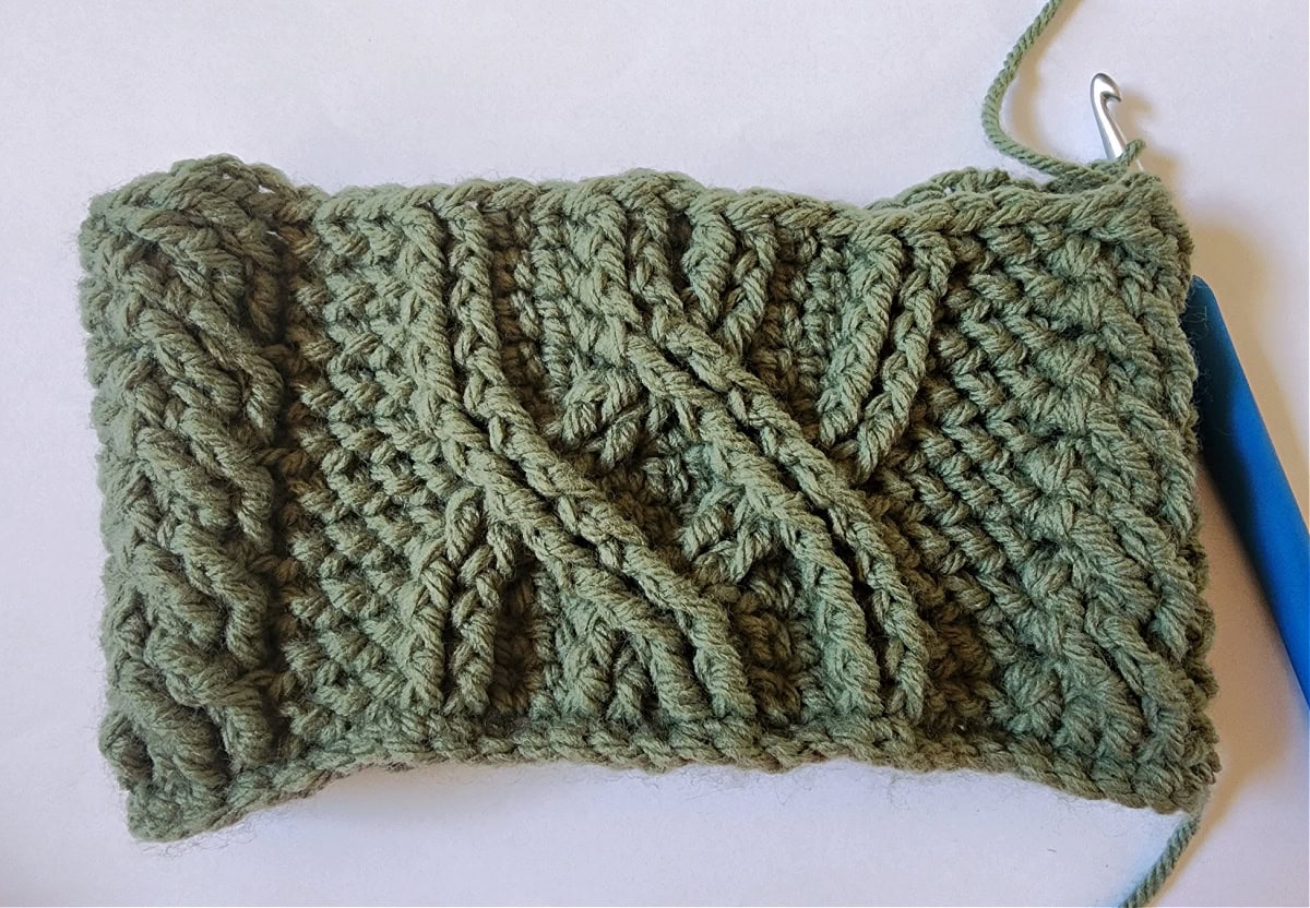 Green crochet Christmas stocking with a celtic crochet cable stitch pattern round 11.