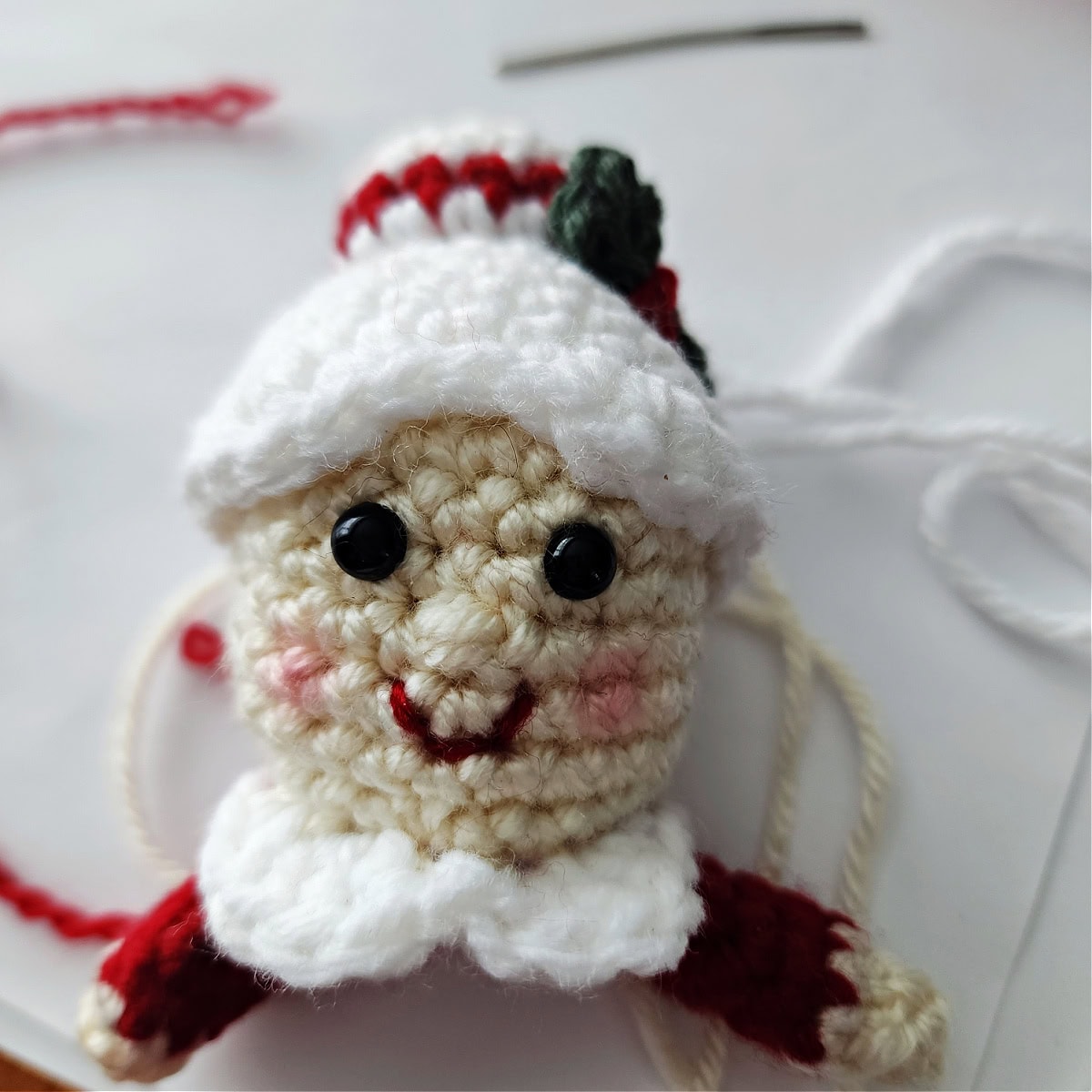 CLose-up of a crochet Mrs Claus ornament.