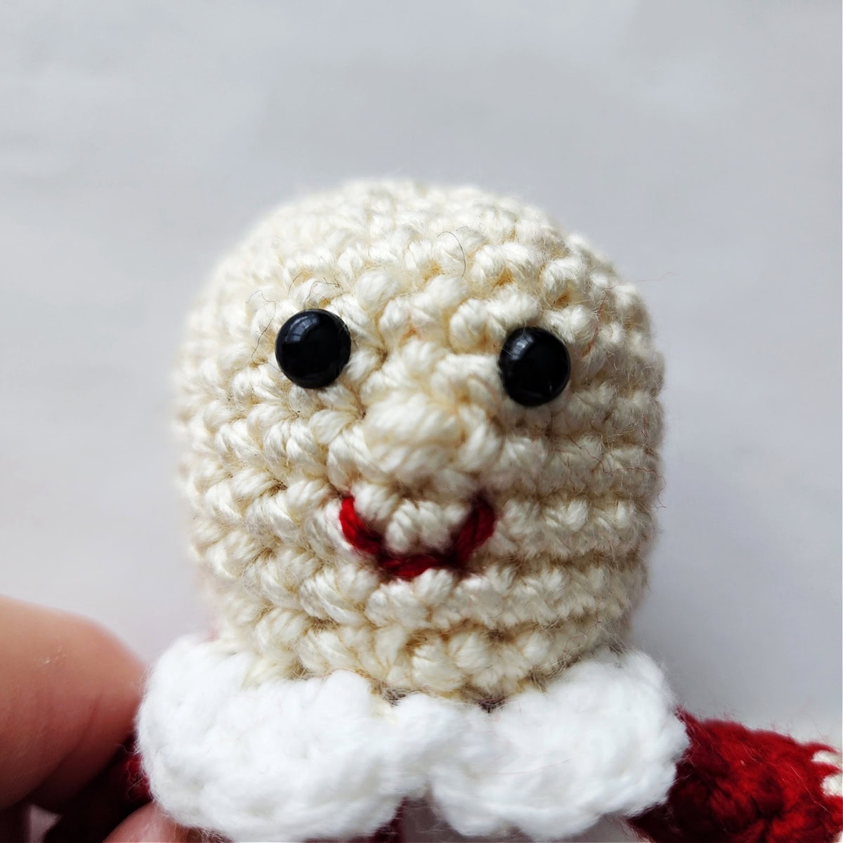 How to embroider a mouth on a Mrs Clause crochet ornament.