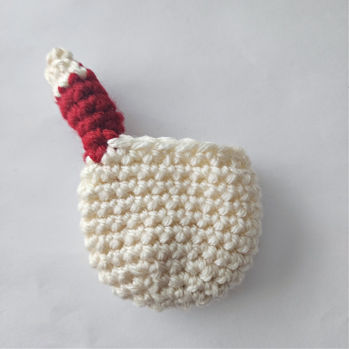 This photo shows one crochet arm complete on the jingle bell ornament.