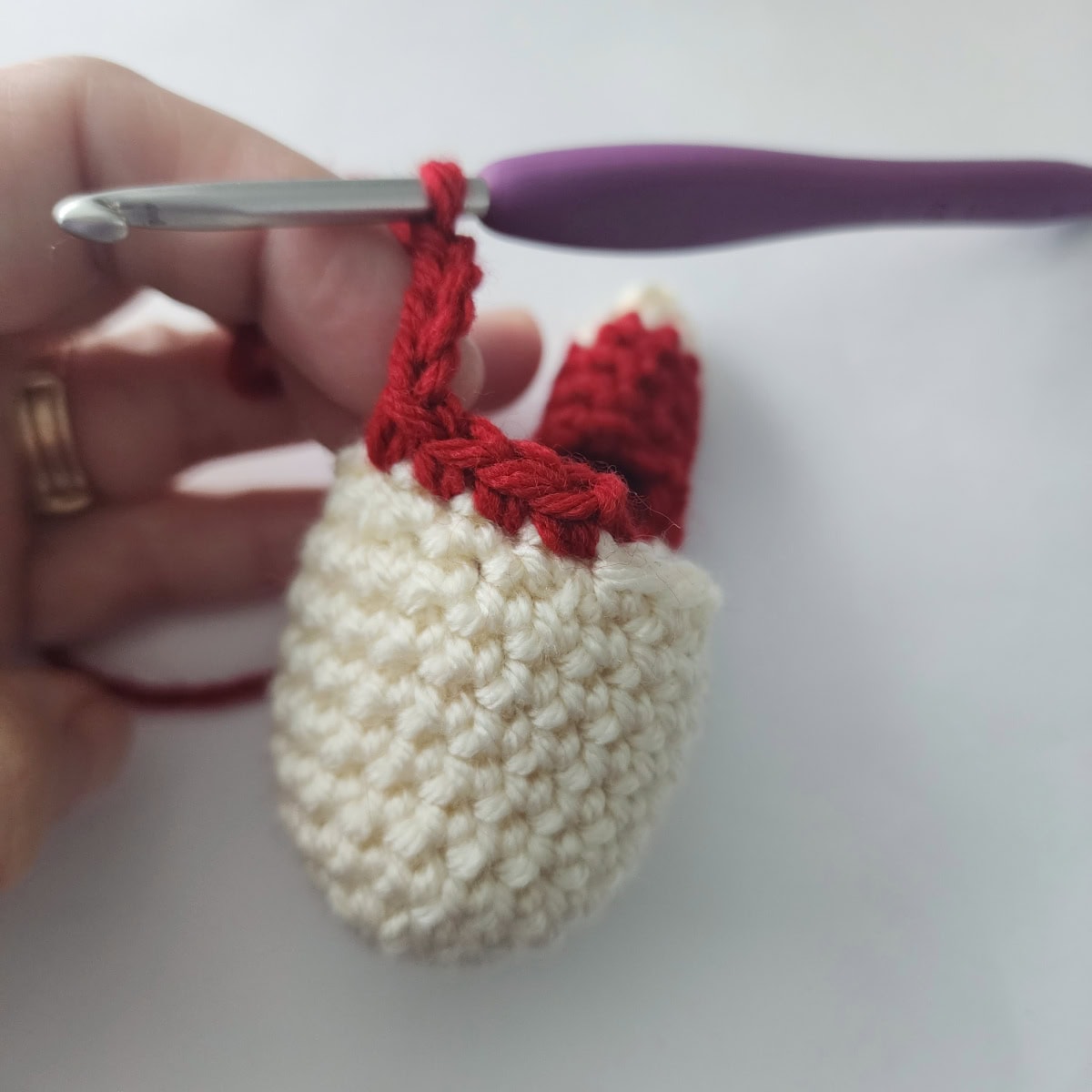 A crochet hook and chain to create a circle for an arm.