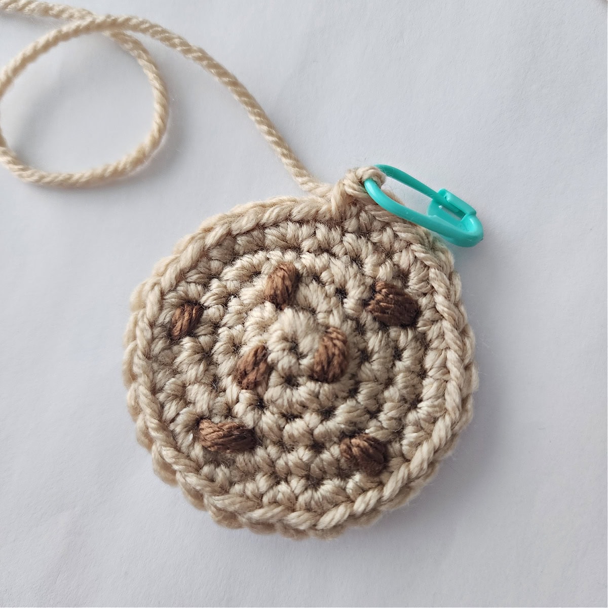 One piece of a crochet chocolate chip cookie that will become an ornament.