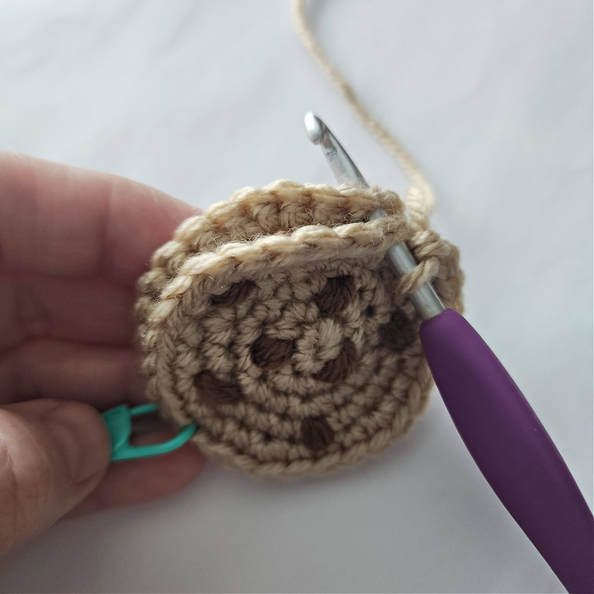 Two crochet cookies being joined with a slip stitch to create the cookie ornament.