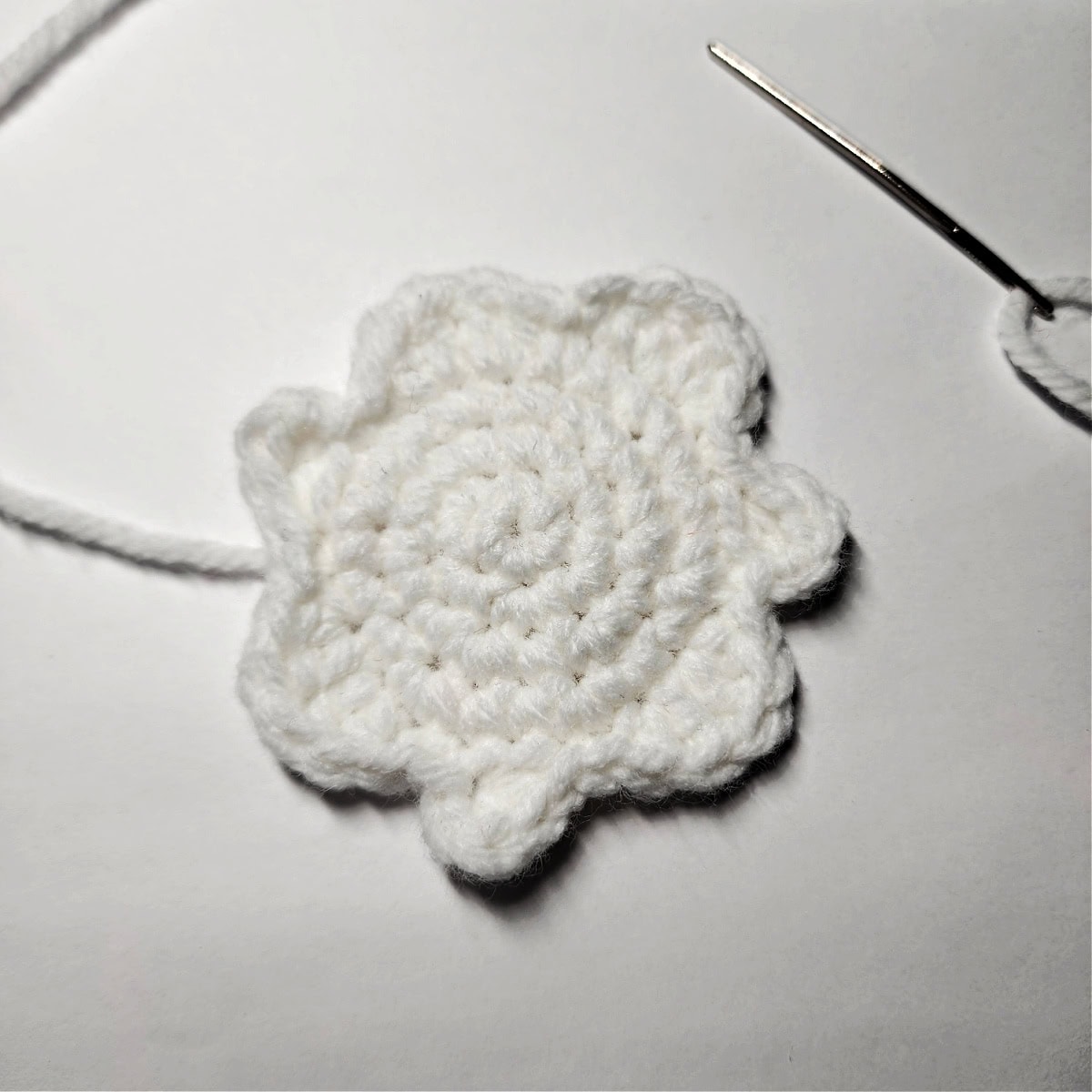 Squiggly white crochet circle for icing hair on gingerbread girl Christmas ornament.