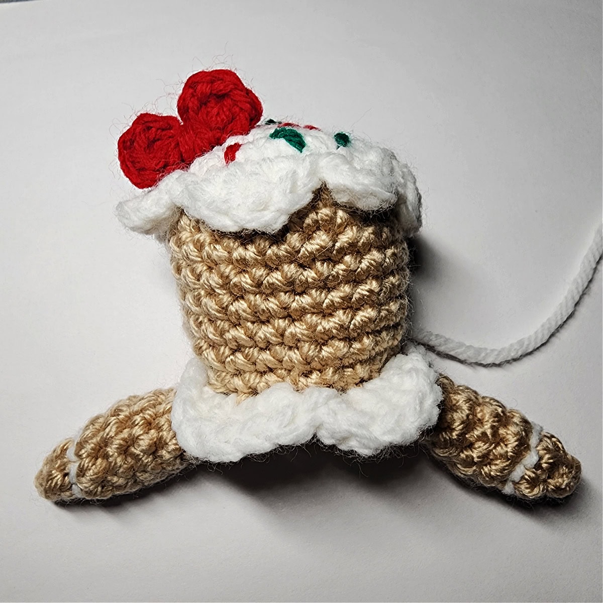 White yarn has been added to the arms of the crochet gingerbread girl.