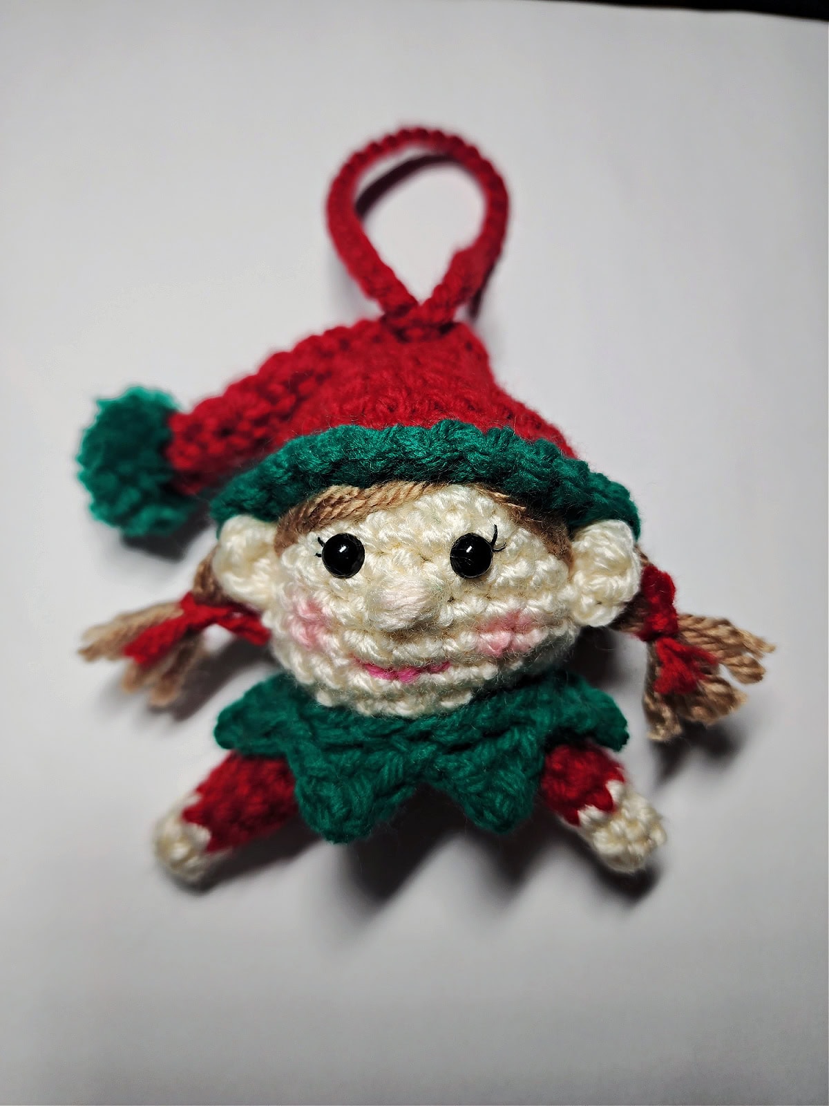 Crochet girl elf with black eyelashes.