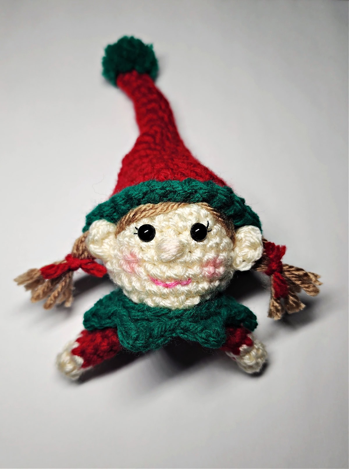 A completed girl elf crochet head for a Christmas ornament.