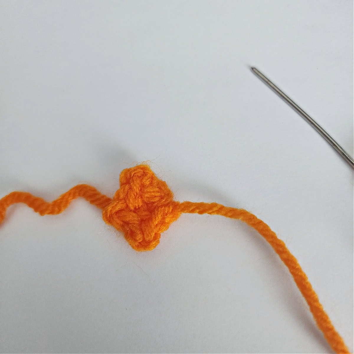 An orange beak for a crochet penguin.