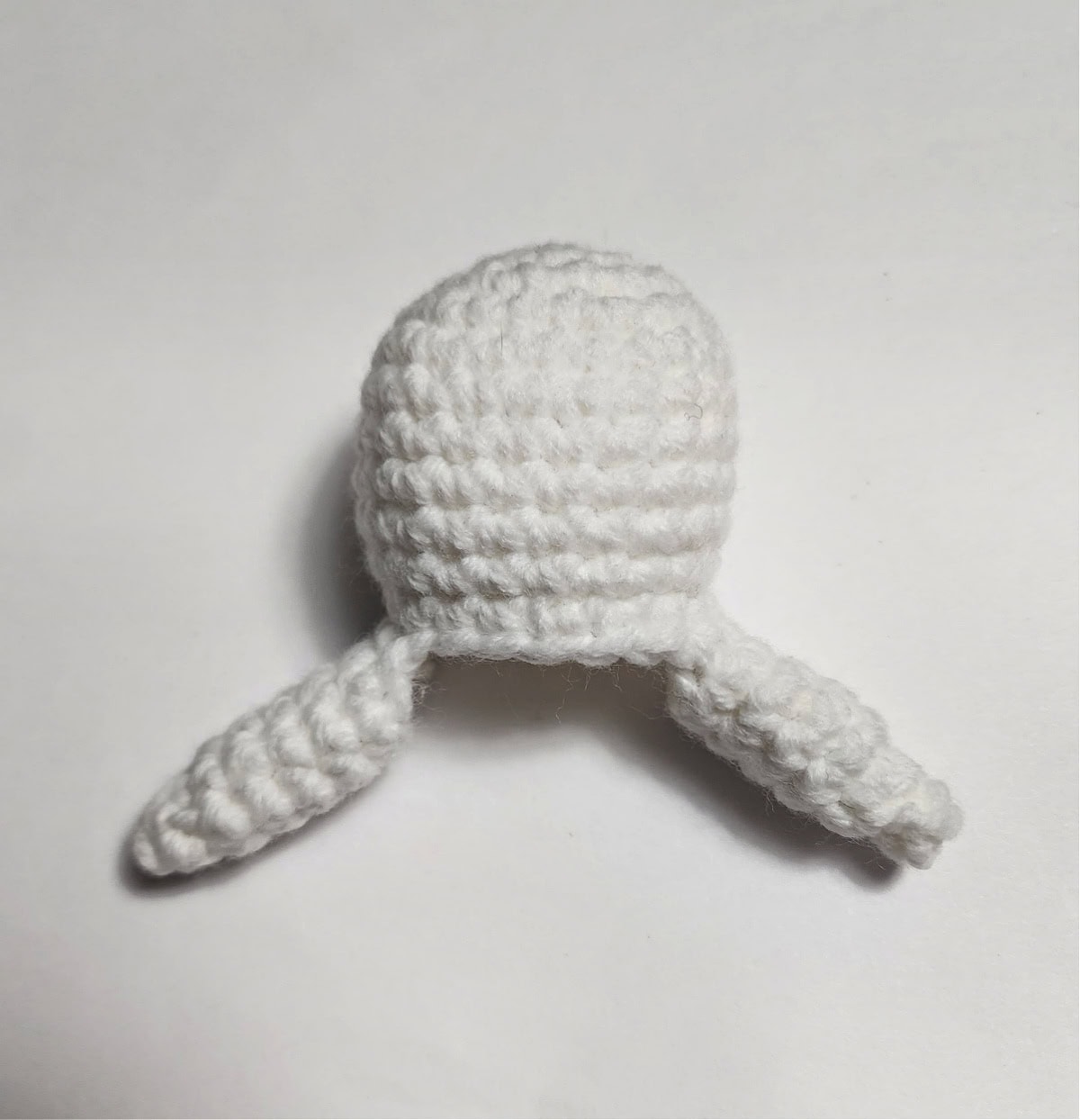 Crochet amigurumi snowman head and arms.