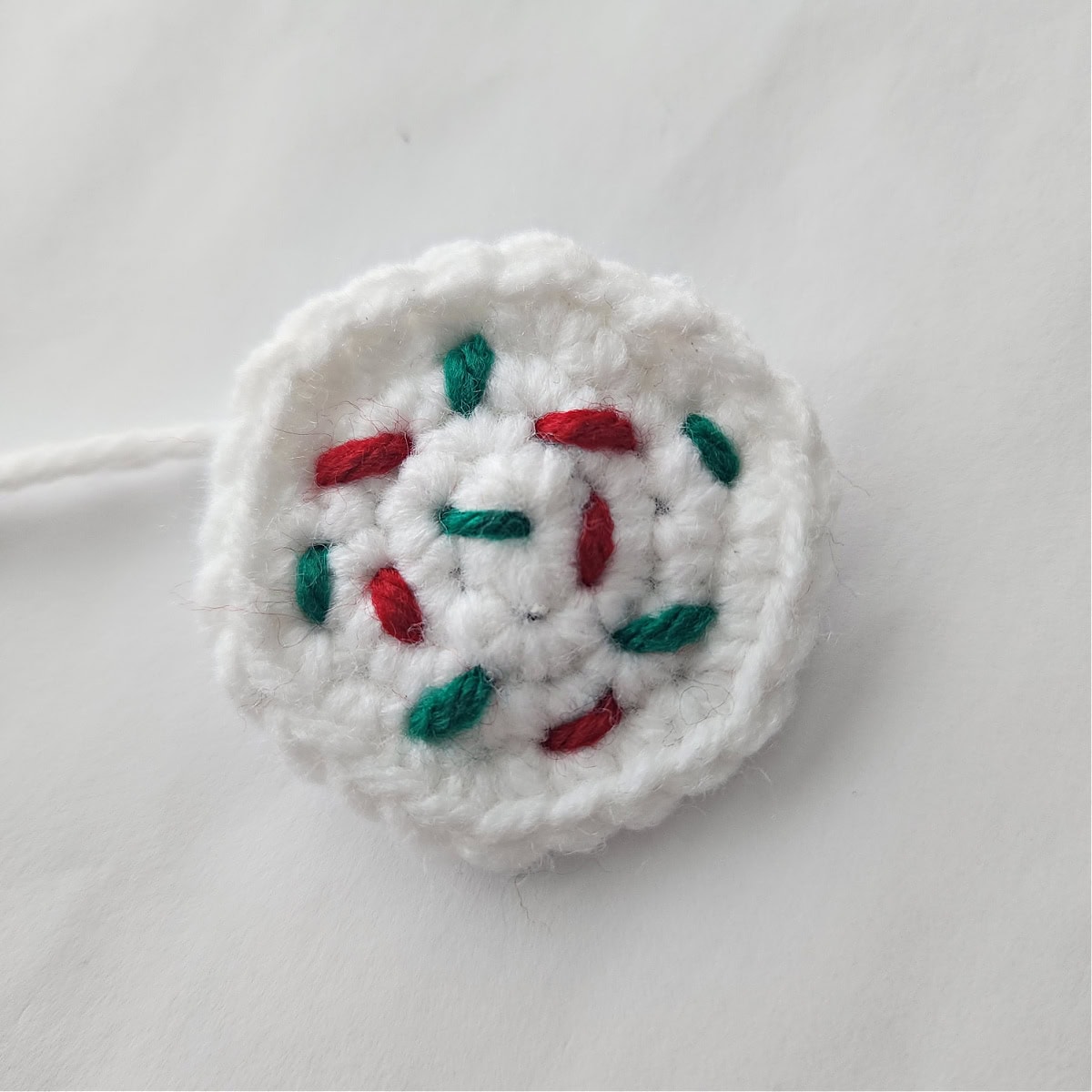 White crochet sugar cookie frosting with red and green sprinkles.