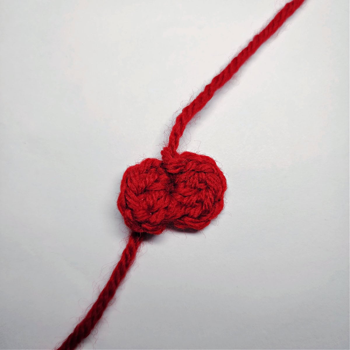 A small red crochet bow before the center is cinched in.