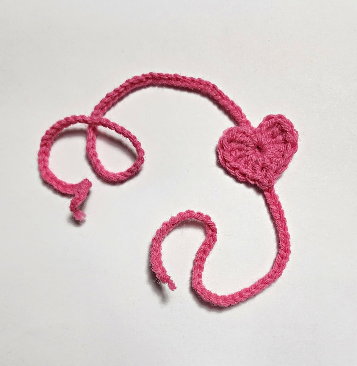 Small pink crocheted heart headband for an American Girl Doll.