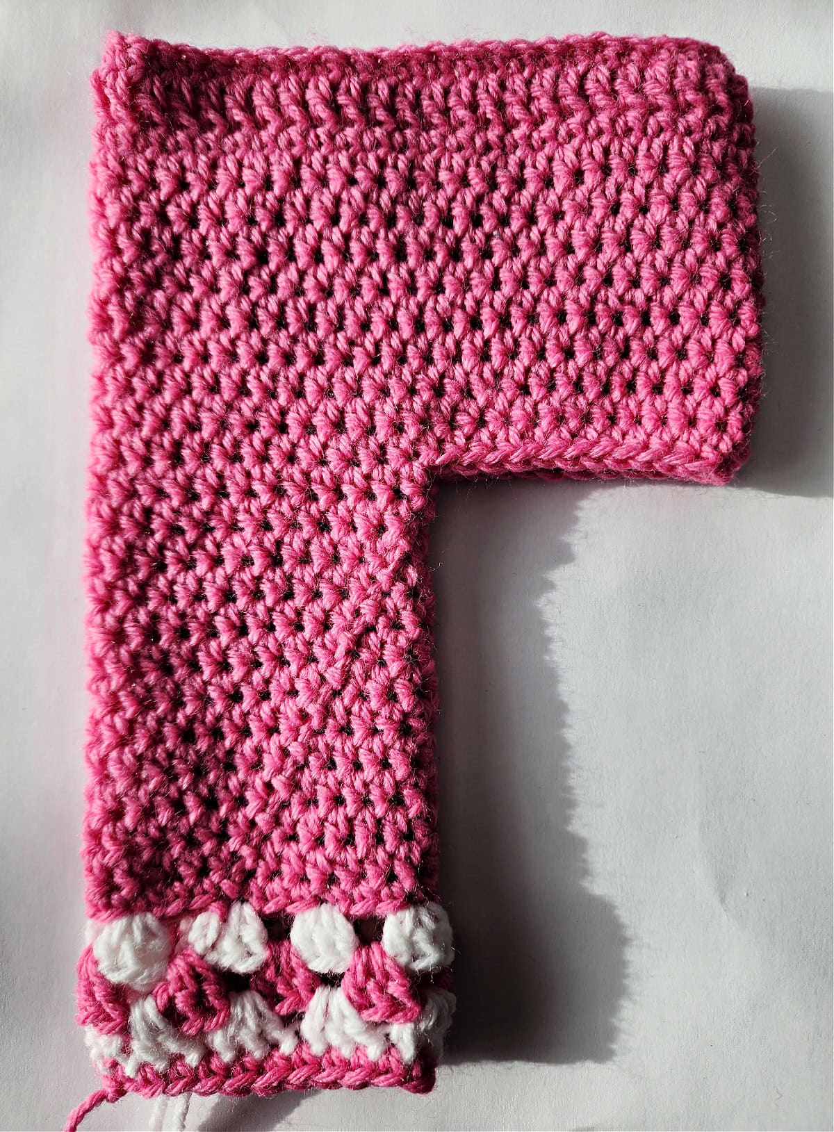 Pink crochet doll pants with one leg complete.