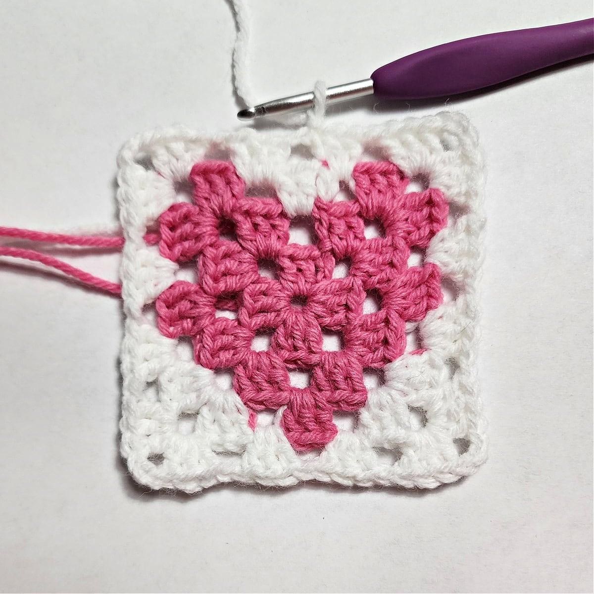 Round four complete of a heart granny square.