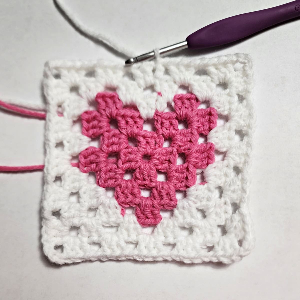 Round five complete of a heart crochet granny square.