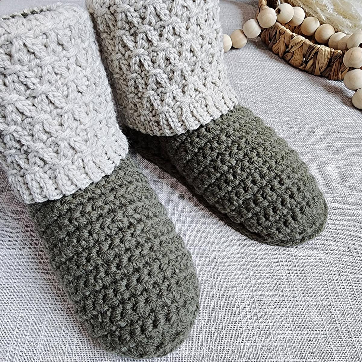 A close-up of the top of crochet booties with knit-look crochet cuffs that resemble knit smocking.